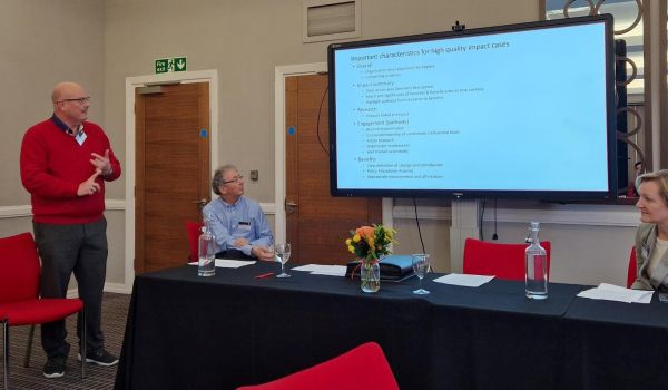 Terrance Warren, Robert Blackburn, and Julia Bell, in front of a powerpoint slide.