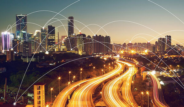 City skyline at night with lit up road and abstract arches showing connectivity