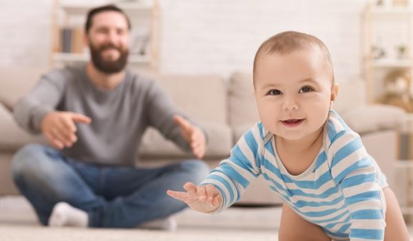 Male looking after a crawling baby