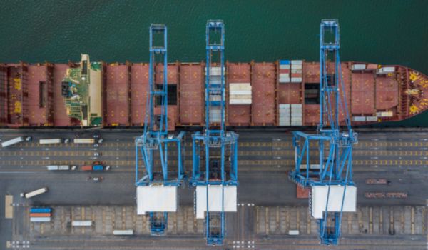 Shipping container at dock with crane loading goods