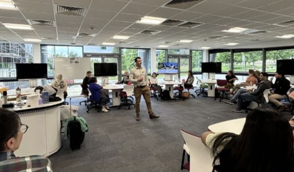 Dr Peter Gittins presenting in the middle of a room