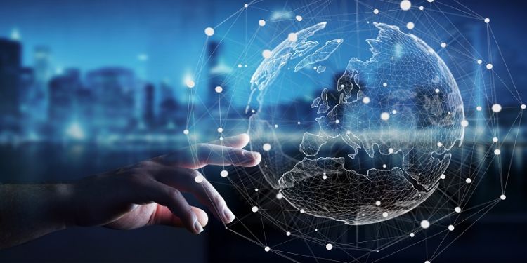 This image shows a an urban skyline in moody blue hues, while an outstretched hand is seen in the foreground attempting to touch an outline of the world interlinked by faint white lines and dots indicative of global networks.
