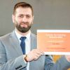 Student Anas, holding his award certificate