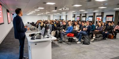 Ghasem Zaefarian stood in front of seated attendees at the welcome session of the Doctoral Conference.