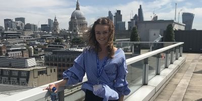 photo of student Emily Hollis standing on a London balcony during her industrial placement year.