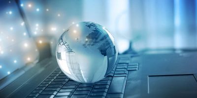 Laptop with a globe resting on it
