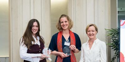 Student Honor McGregor and mentor Charlotte Woods holding their awards for Relationship of the Year next to Executive Dean Professor Julia Bennell.