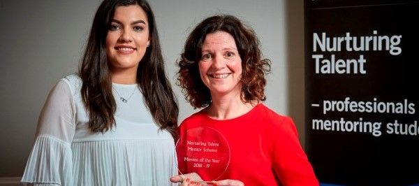 Mentor and mentee stood with an award