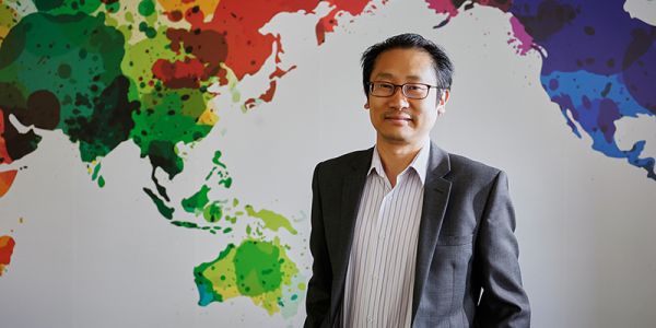 Chee Yew Wong with colourful paint splatter background