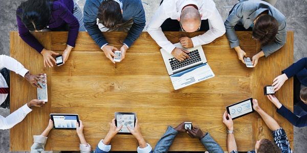 People around a table using computer devices 800 x 400