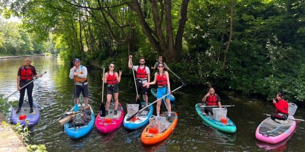 Paddleboarding team collecting litter