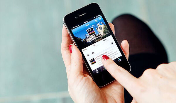Close of a person using a phone to post to social media