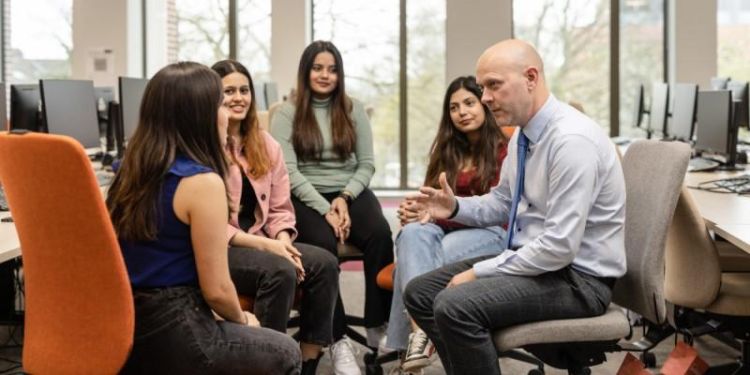 Students sitting around a Tutors chatting