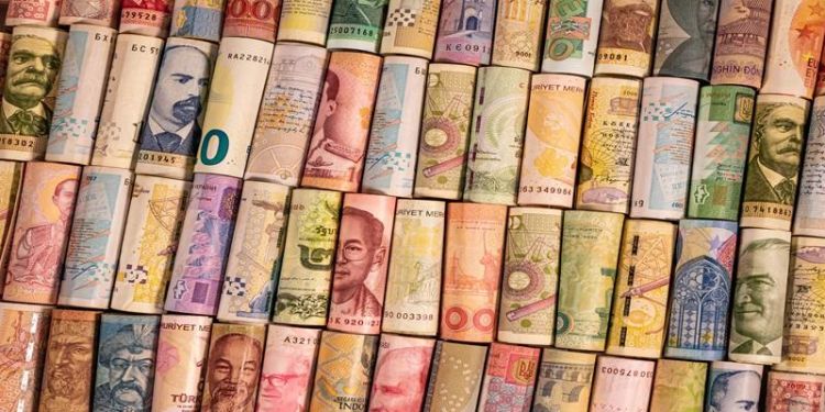 The picture shows multi-coloured international bank notes, rolled up in several rows.