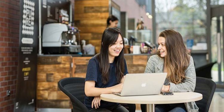 Undergraduate students with a laptop in Charles Thackray foyer