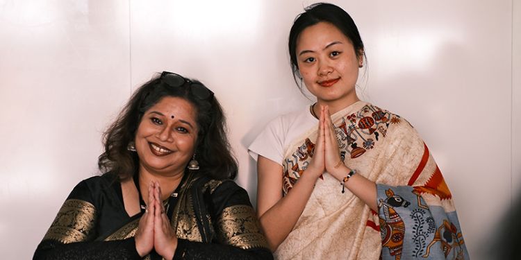 Dr Meenakshi Sarkar stands with a student, they are both wearing traditional sarees