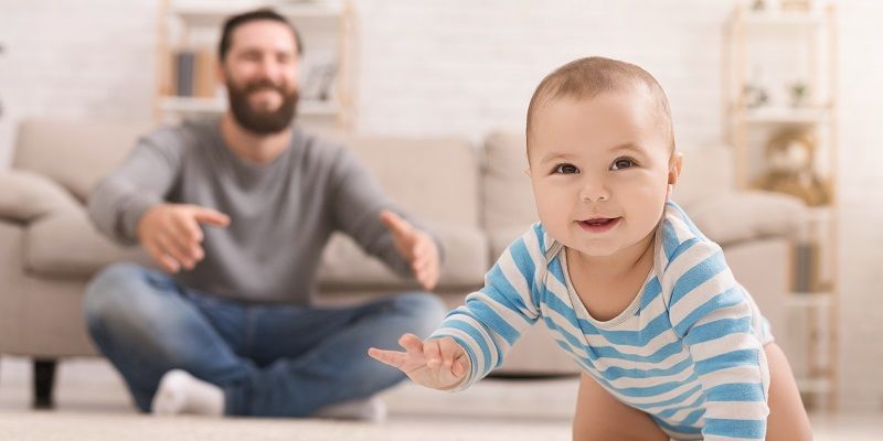 Male looking after a crawling baby